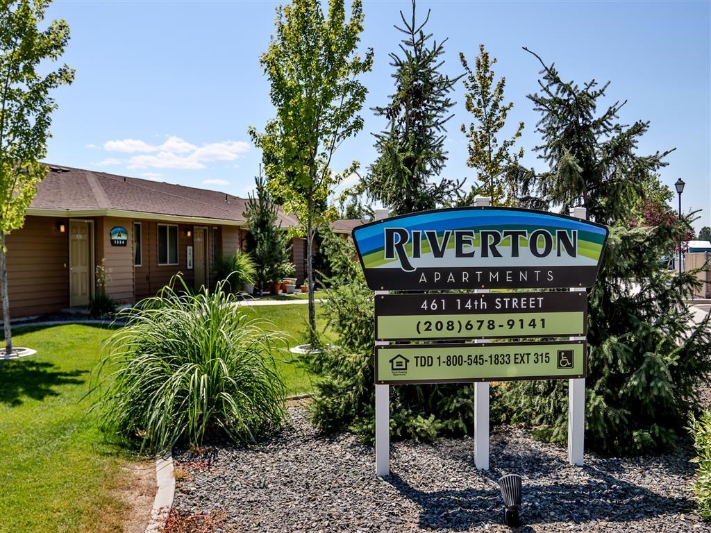 a sign for riverton apartments in front of a house