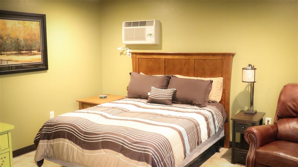 a bedroom with a bed and a air conditioning unit on the wall