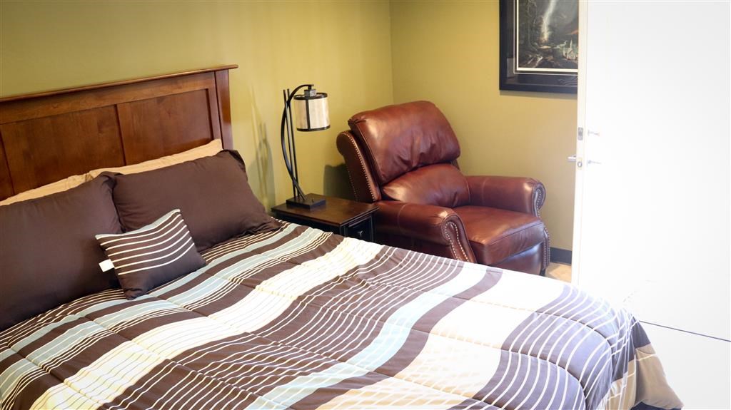 a bedroom with a bed and a leather chair