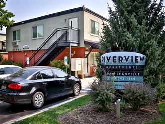 a car parked in front of a sign for riverview apartments