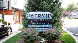 a sign for riverview apartments in front of a street