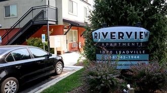 a car parked in front of a riverview apartments sign
