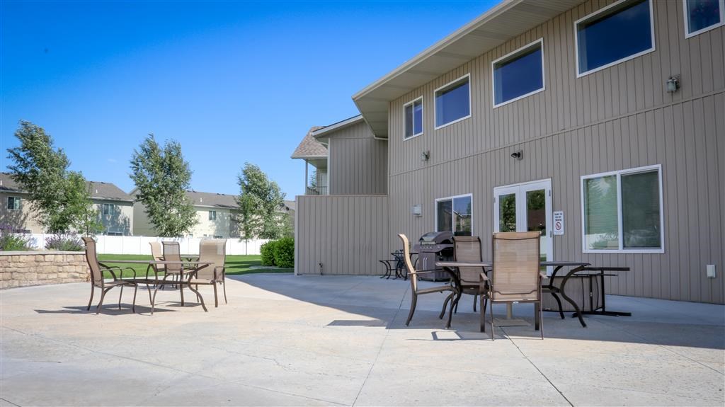 a patio with tables and chairs in front of a building