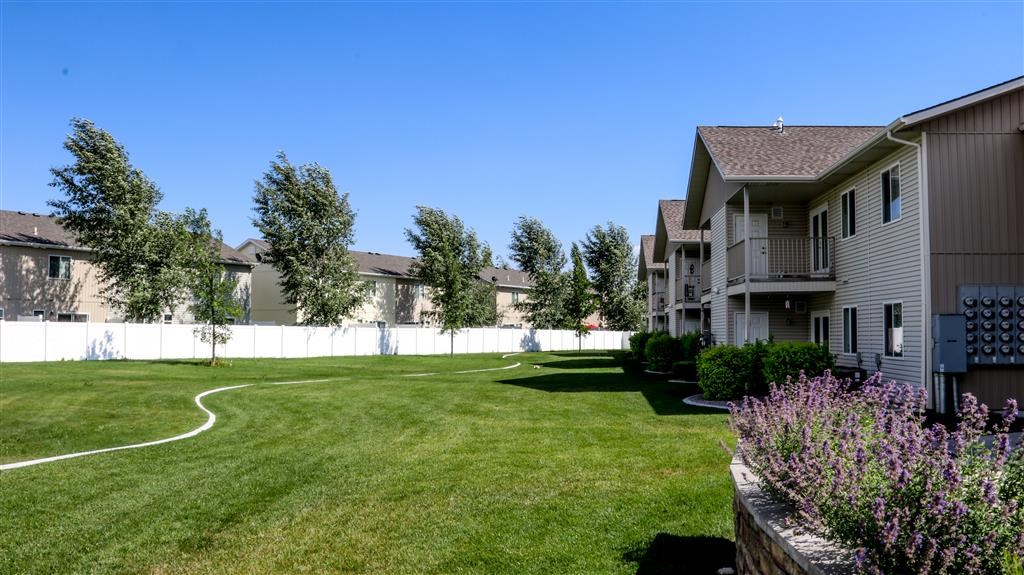 a yard in front of a house with a fence