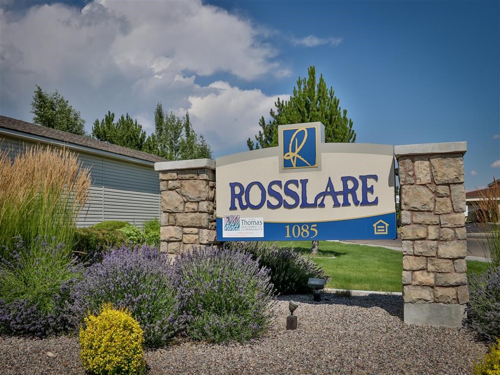 a sign for rosolare apartments in front of a garden