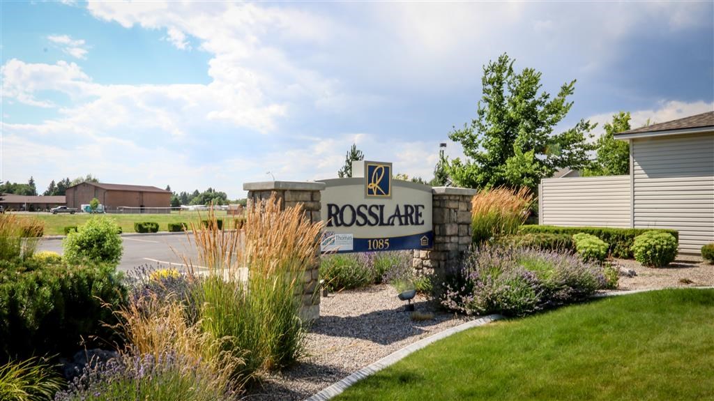 a sign for roosalare apartments in front of a parking lot