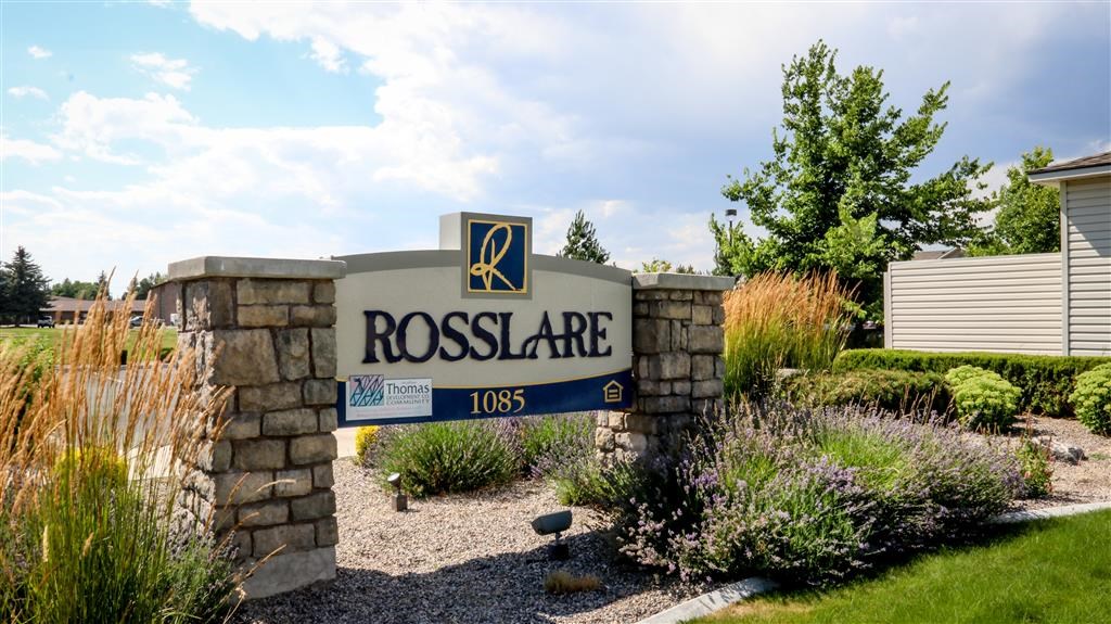 a sign in front of a flower garden