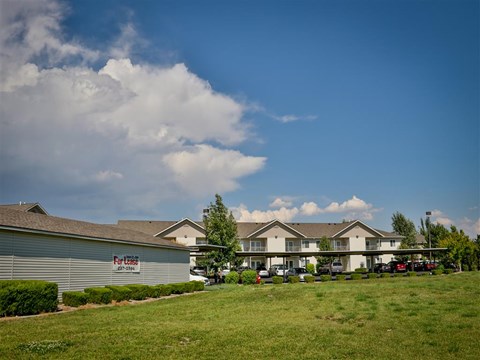a row of houses with a green lawn and a blue sky