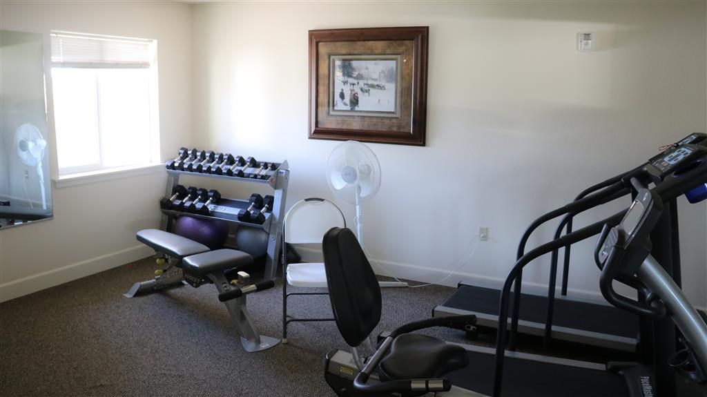 a gym with a chair and equipment in a room