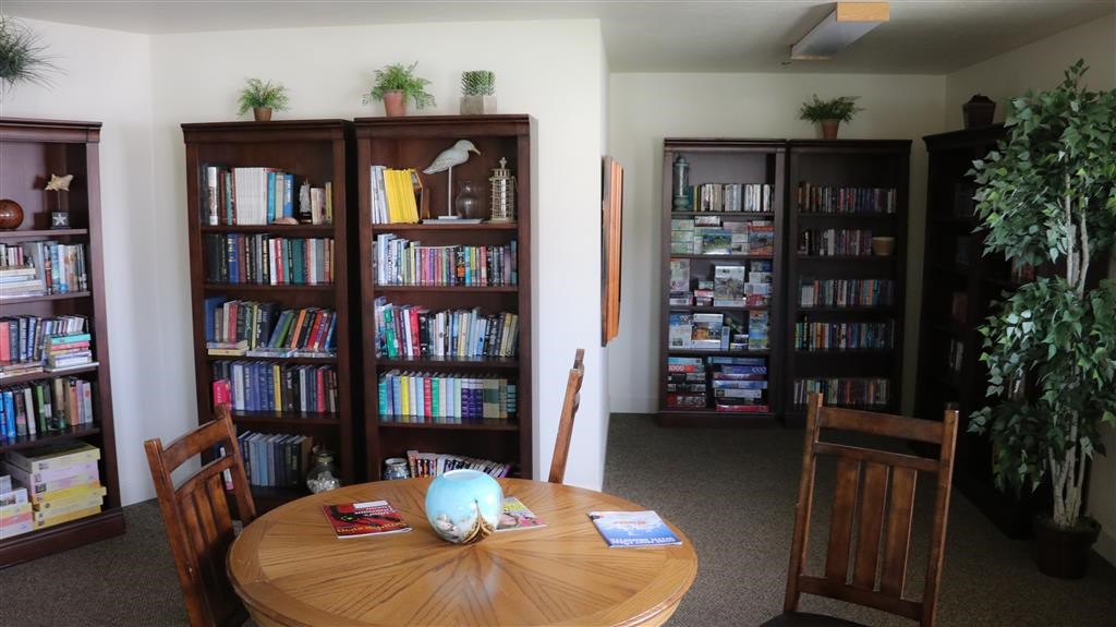 a library with a table and chairs and bookshelves