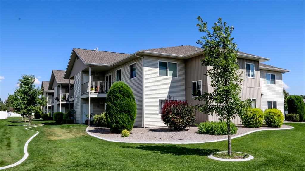 an apartment building with a yard and trees