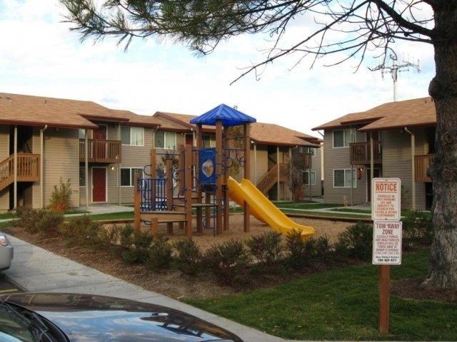 an empty playground in front of an apartment complex