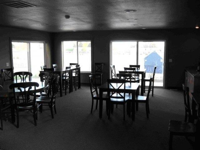 a dining room with tables and chairs and windows
