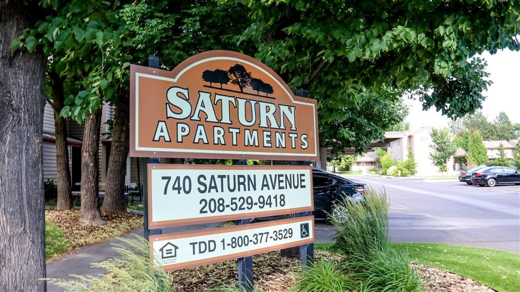 a sign for the saturn apartments on the side of the street