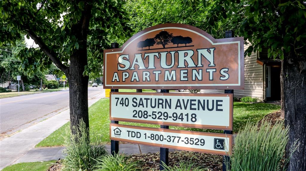 a sign for the saturn apartments on the side of the street