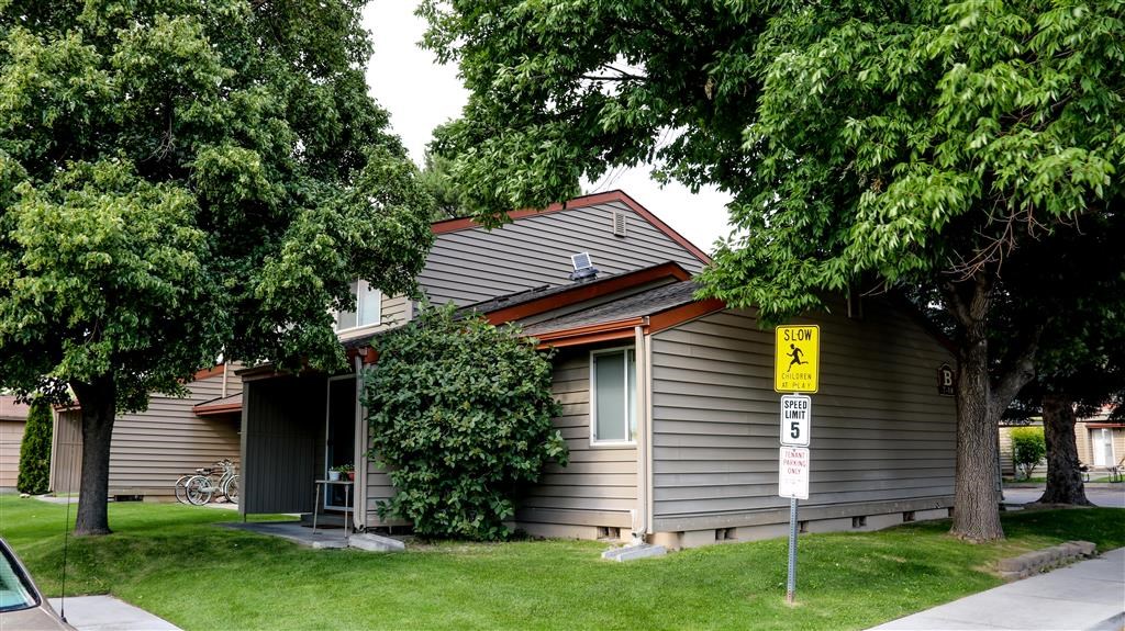 a gray house with a yard and trees