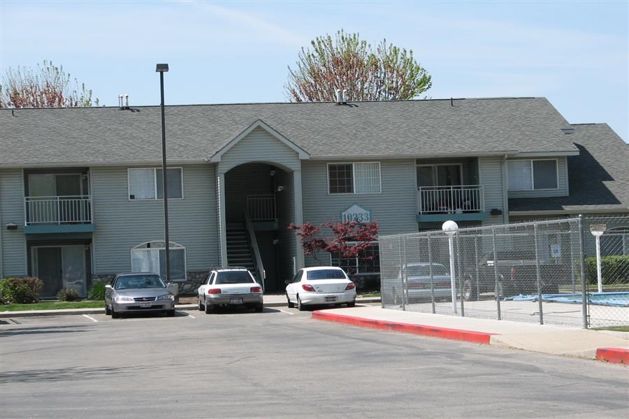 an apartment building with cars parked in front of it