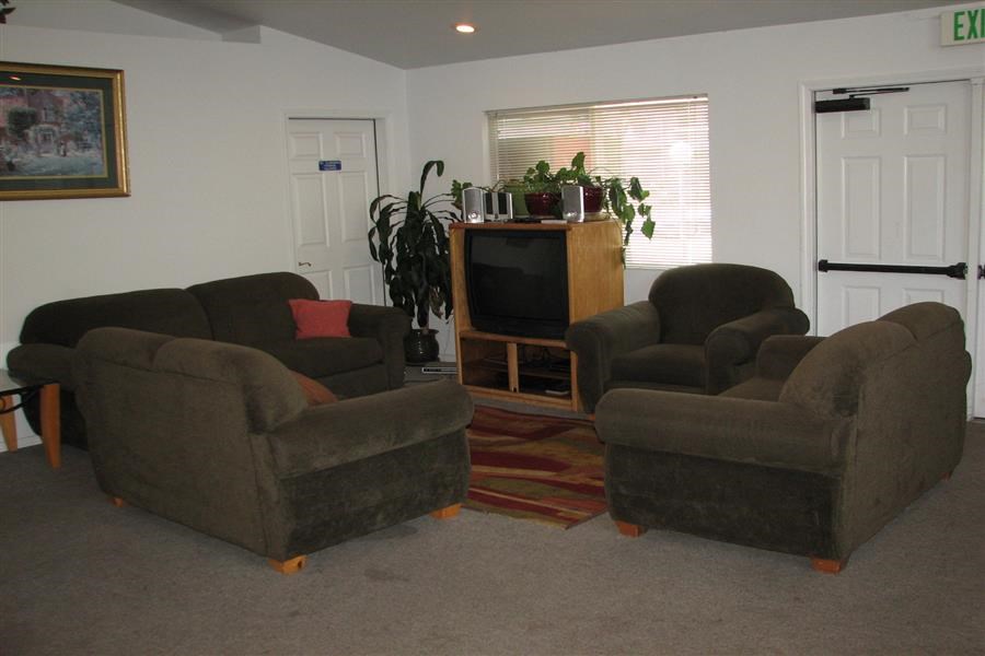 a living room with three chairs and a television