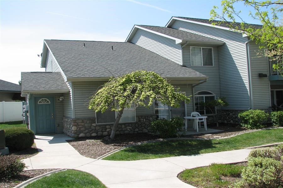 a gray house with a tree in front of it