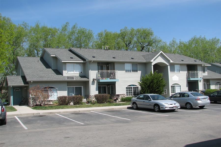 a apartment building with cars parked in a parking lot