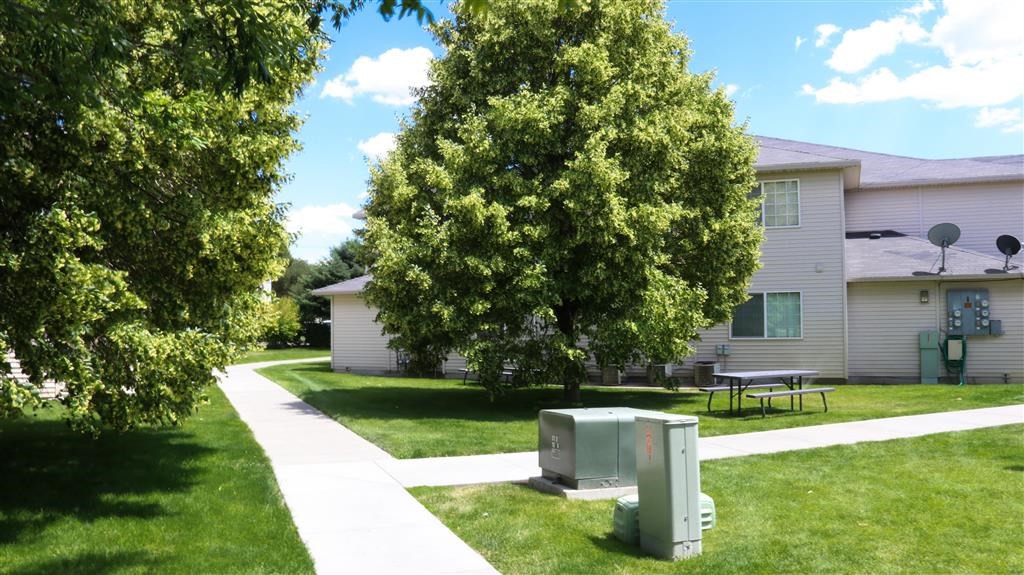a refrigerator sitting in the grass in front of a house