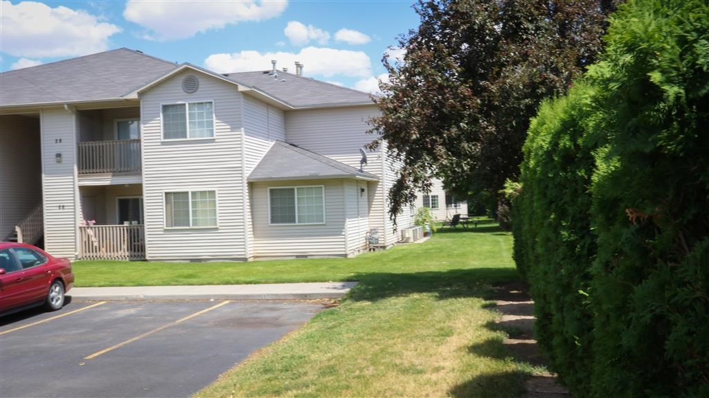 a white house with a red car parked in front of it