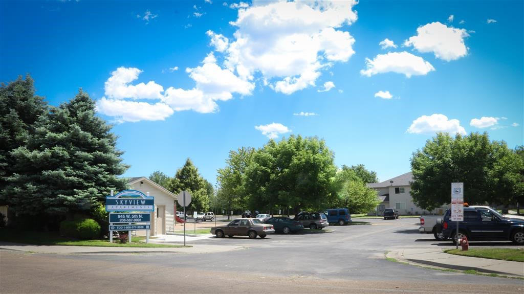 a parking lot with cars parked in front of a building