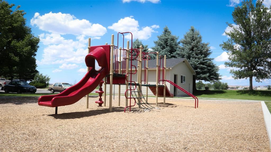 a playground with a slide and climbing equipment in a park