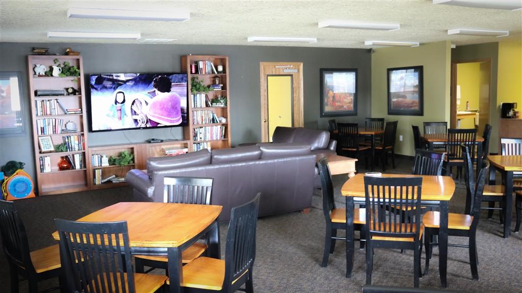 a living room with tables and chairs and a tv