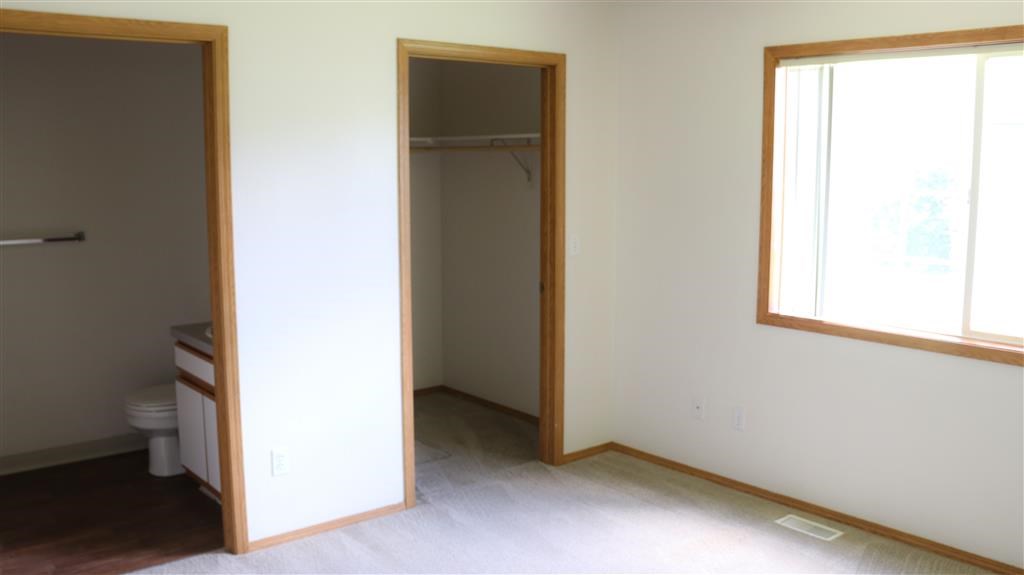 an empty room with a toilet and a door to a bathroom