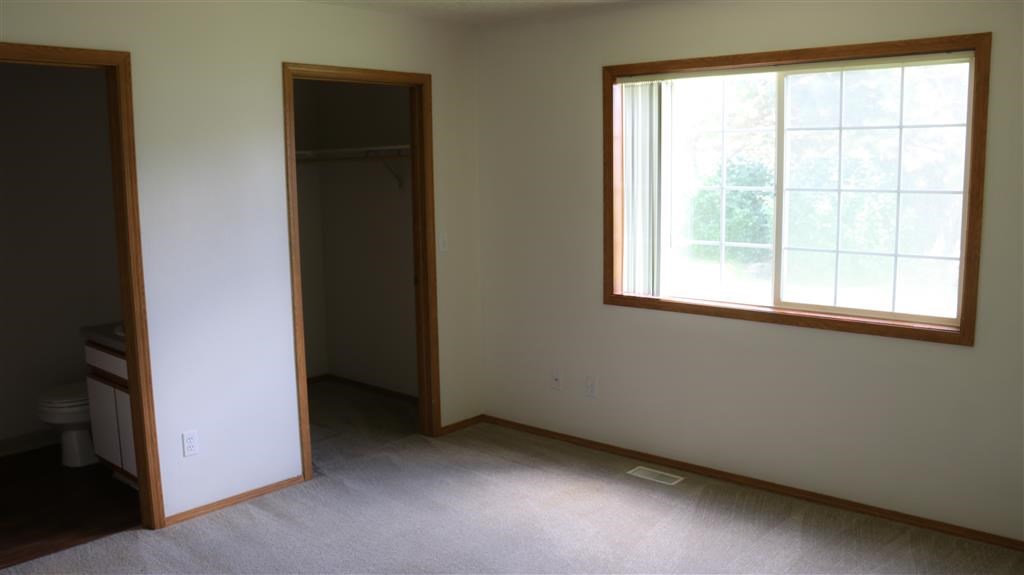 an empty room with a window and a closet