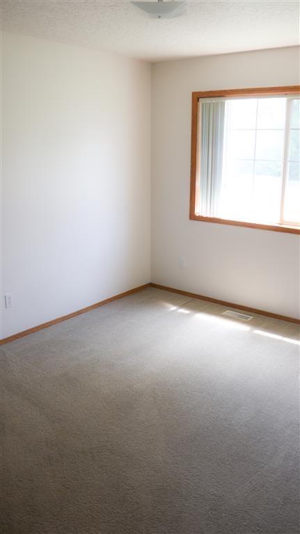 an empty room with a window and a carpet