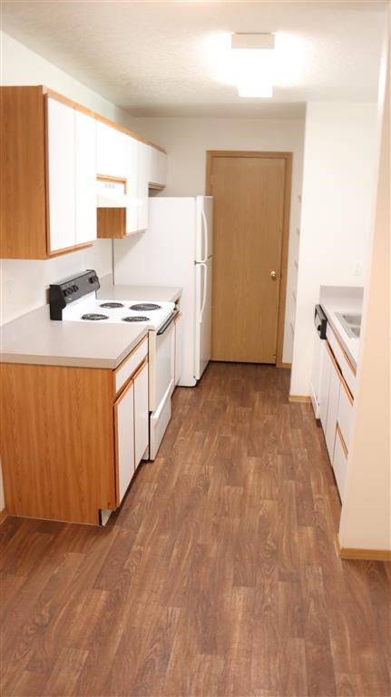 an empty kitchen with a stove and a refrigerator