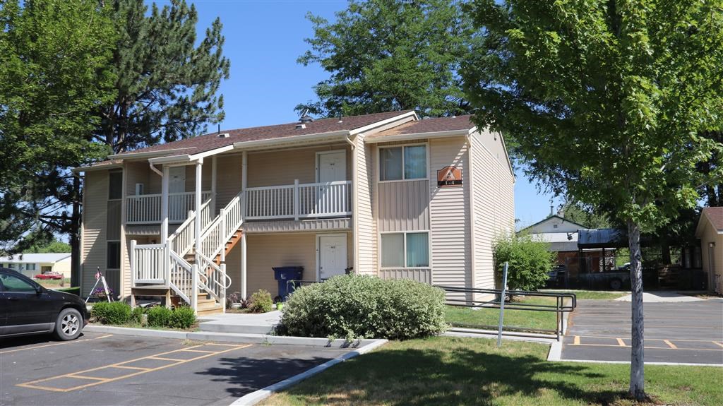an apartment building with stairs and a parking lot