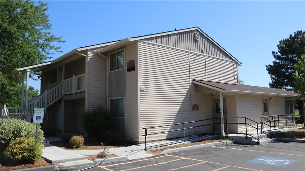 the outside of a building with stairs and a parking lot