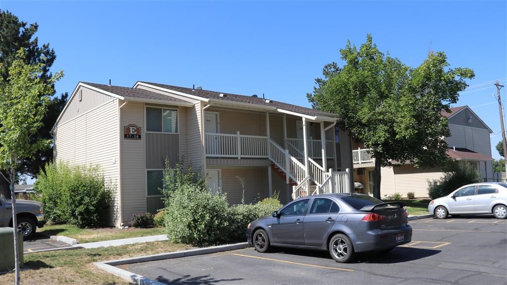 an apartment building with a car parked in a parking lot