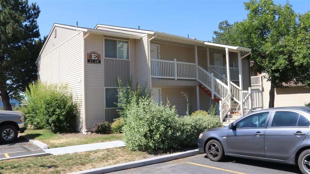 an apartment building with a car parked in front of it