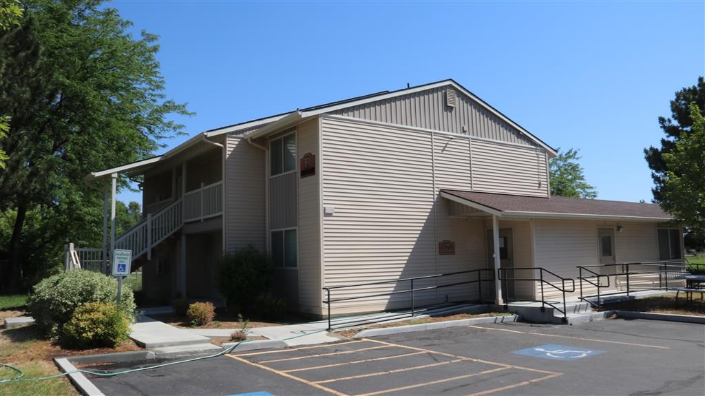a white building with a ramp and a parking lot