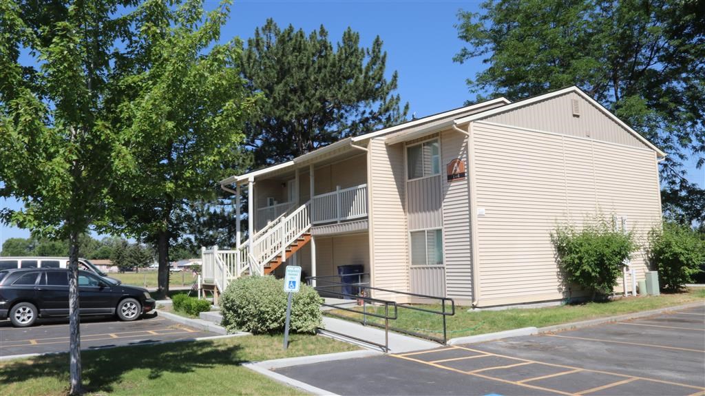 an apartment building with a car parked in a parking lot