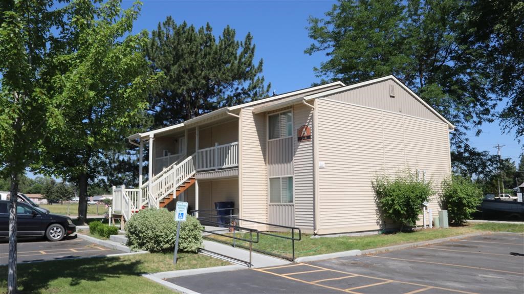 an apartment building with stairs and a parking lot