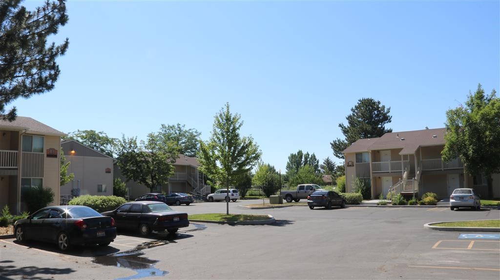 a parking lot with cars in front of apartment buildings