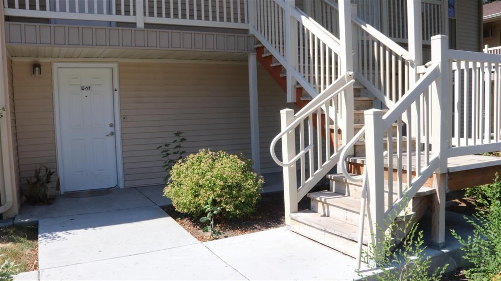 the front door of an apartment building with stairs and a white door