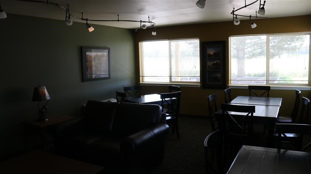 an empty living room with a table and chairs
