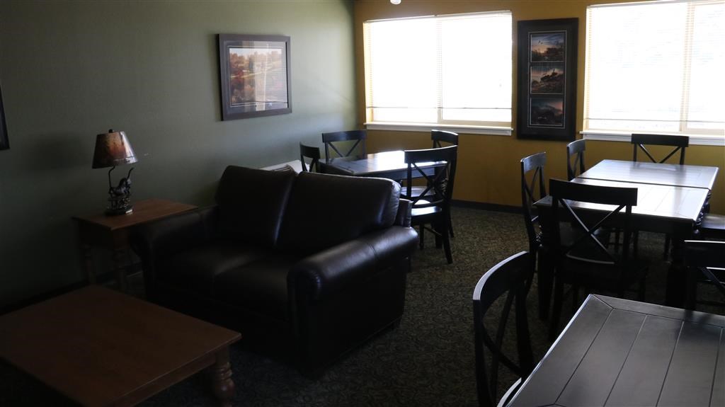 a living room with a leather couch and a table and chairs