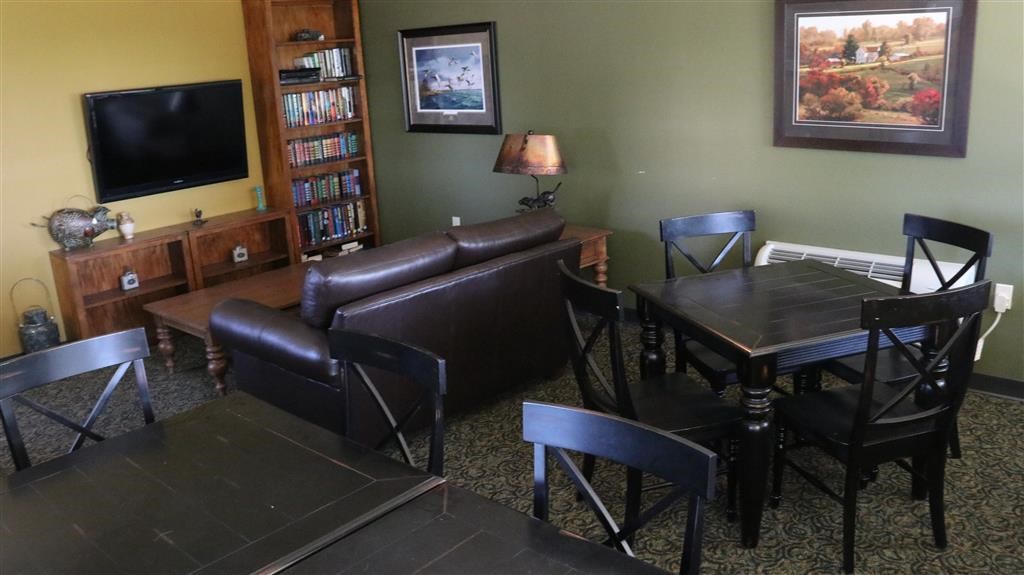 a living room with a couch table and chairs and a television