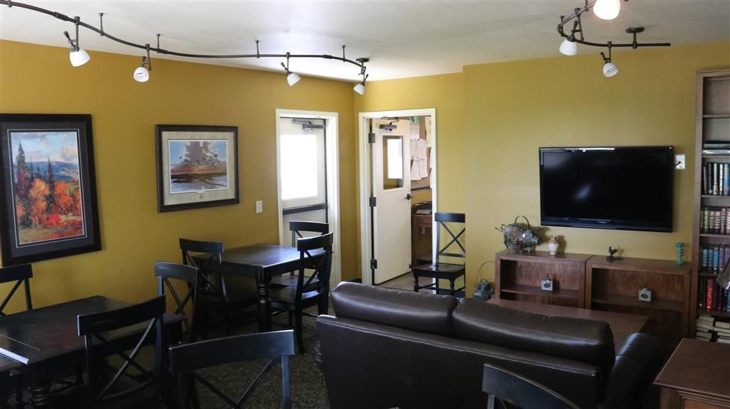 a living room with a couch and chairs and a television