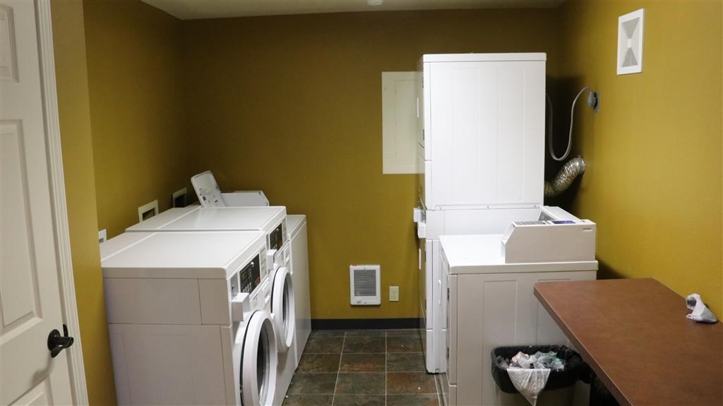a laundry room with two washing machines and a refrigerator