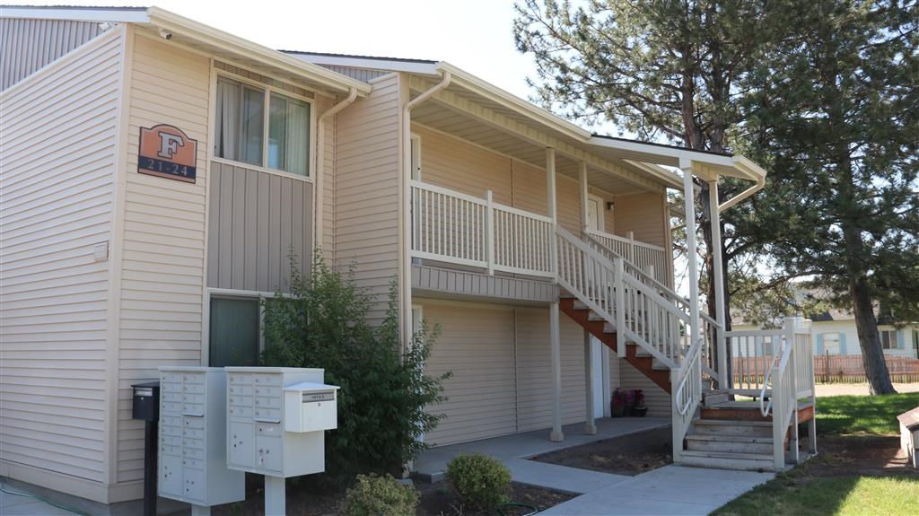 an apartment building with a staircase and mailboxes
