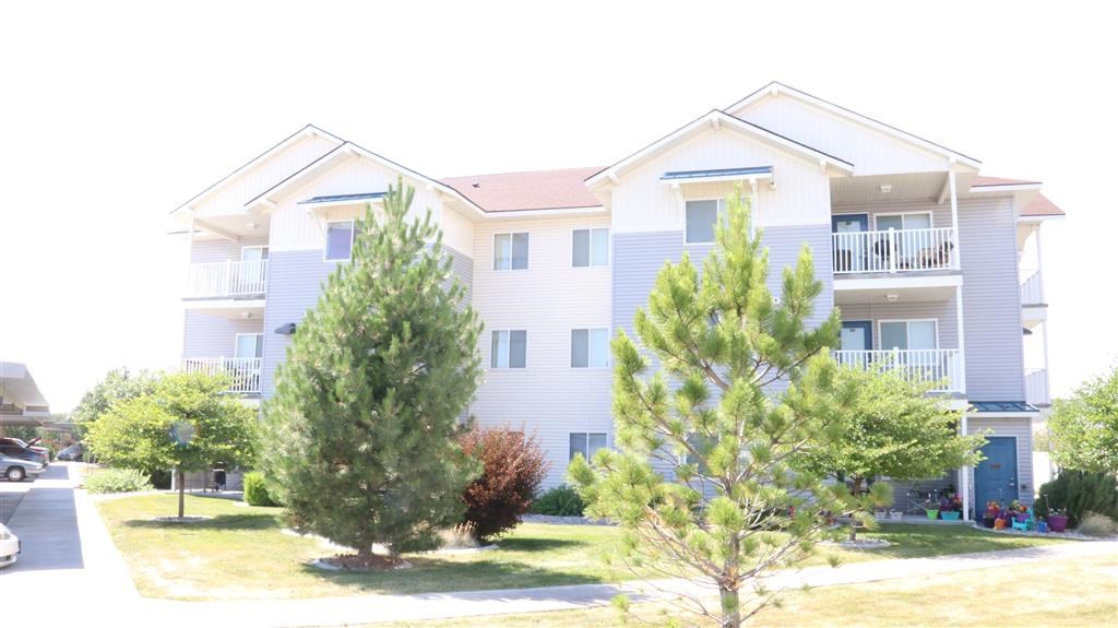 the exterior of an apartment building with trees in front of it