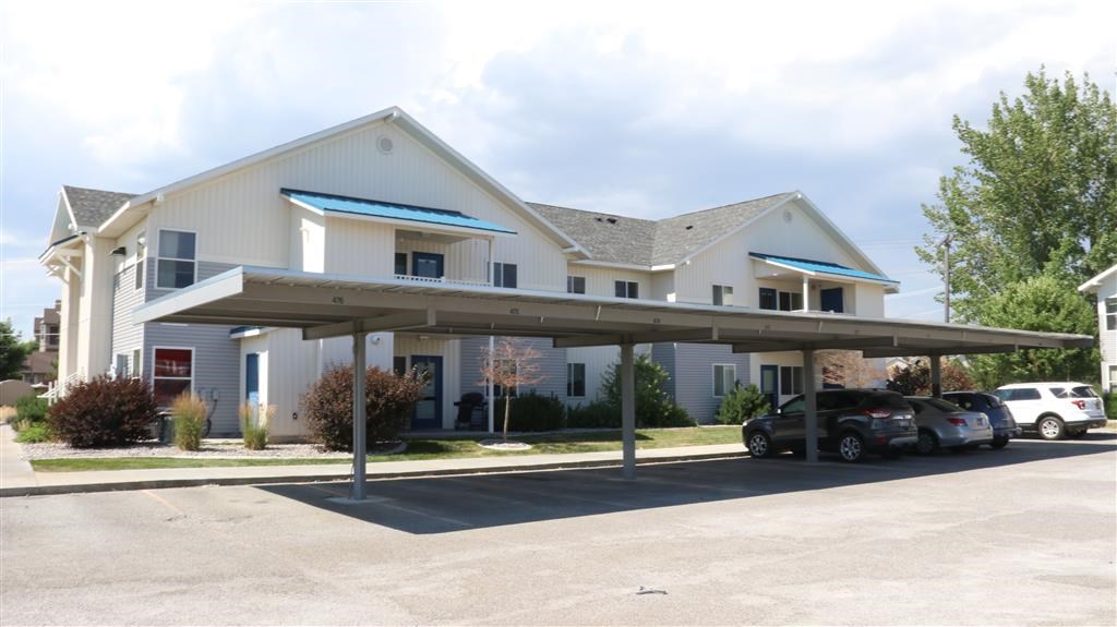 a white house with cars parked in a parking lot